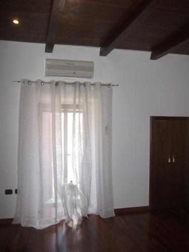 a window with white curtains in a room at Dimora di Mara in Santeramo in Colle