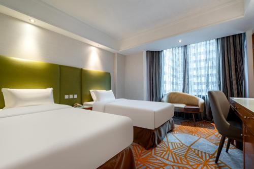 um quarto de hotel com duas camas e uma escrivaninha em Wharney Hotel em Hong Kong