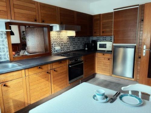 a kitchen with wooden cabinets and stainless steel appliances at Lüttje Tied in Walsrode