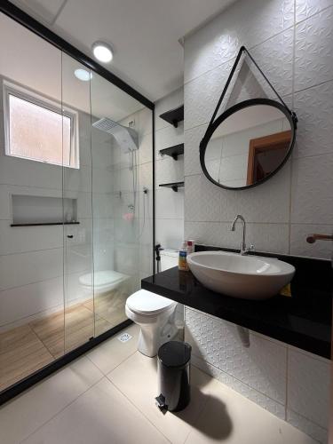 a bathroom with a sink and a toilet and a mirror at AP da FLOR Guerra in Parnamirim