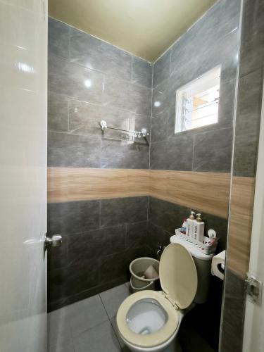 a small bathroom with a toilet and a window at Casa Uno Leyte in Palo
