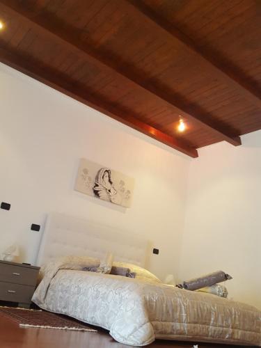 een slaapkamer met een bed en een houten plafond bij Dimora di Mara in Santeramo in Colle