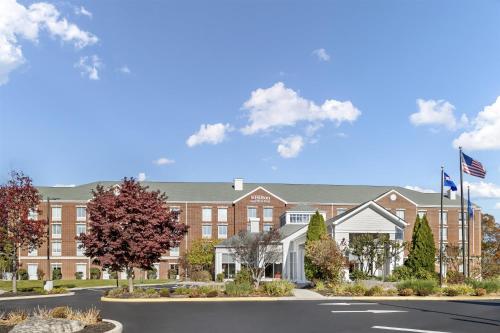 a large brick building with a street in front at Hilton Garden Inn Mystic/Groton in Groton