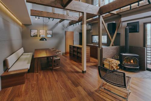 a living room with a table and a fireplace at Villa El Cielo Myoko in Myoko