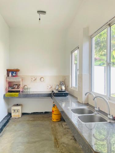 a kitchen with a sink and a window at Kapuwatta Pool Villa in Weligama