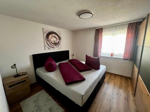 a bedroom with a bed with red pillows on it at Apart Alpenflair 74 in Fliess