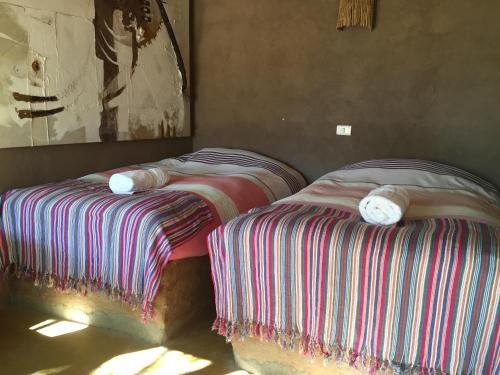 two beds sitting next to each other in a room at Lodge Altitud in San Pedro de Atacama