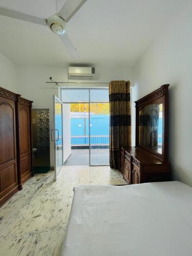 a bedroom with a bed and a sliding glass door at Kapuwatta Pool Villa in Weligama