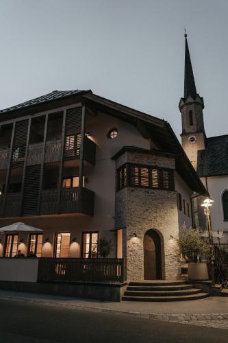 a building with a steeple and a church at stieg'nhaus Design Boutique Hotel in Mühlbach am Hochkönig