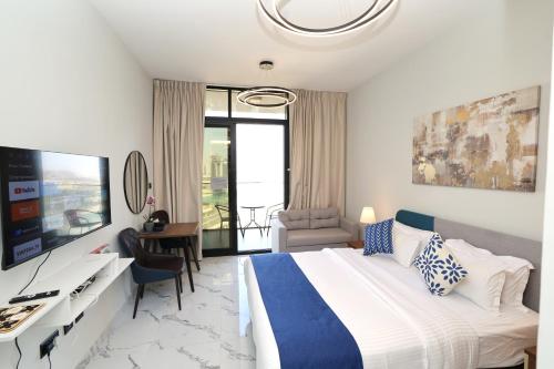 a bedroom with a bed and a desk and a television at Chic Studio near Cleveland by Central Stay in Abu Dhabi
