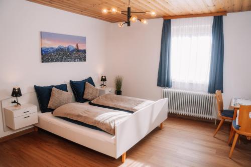 a bedroom with a white bed in a room at Alpenblick Gösweiner in Windischgarsten