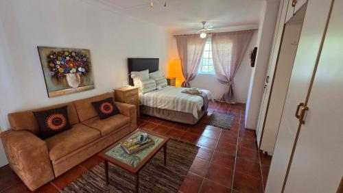 a living room with a couch and a bed at TheBlueDoor in Greyton