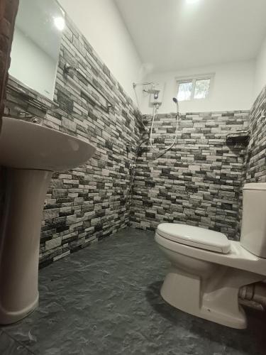 a bathroom with a toilet and a sink at Ranthilaka Villas in Kandy