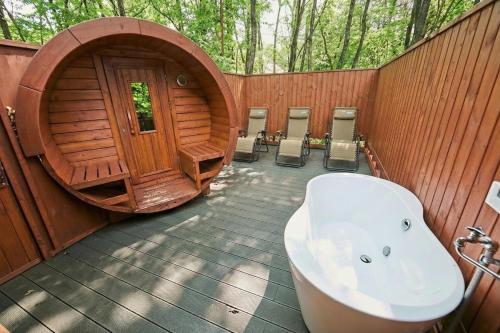 a bathroom with a bath tub and a wooden building at LEVATA Nasu バレルサウナ付きログハウス BBQ可 1棟貸切 6名様まで同料金 in Nasu