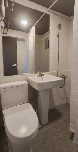 a bathroom with a white toilet and a sink at 낙원파크포도홈 in P'ungnyŏn-gol