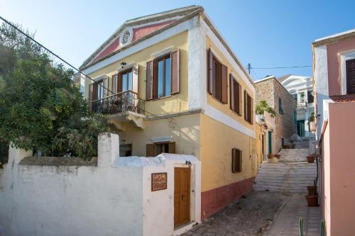 an alley way with a building with a gate and stairs at Galini & Serena Apartments in Symi