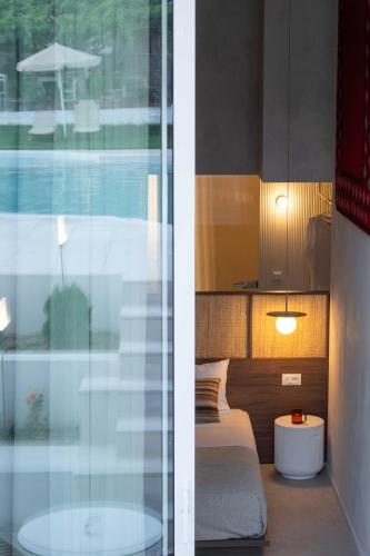 a bedroom with a bed and a glass window at Theros in Rethymno