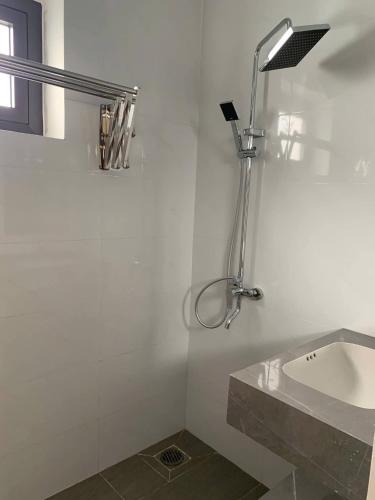 a white bathroom with a sink and a shower at Magallanes Escape in Manila