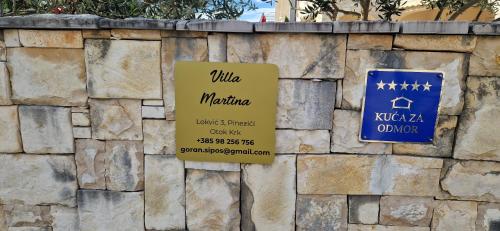 a stone wall with two signs on it at Villa Martina s bazenom,5 soba in Pinezici