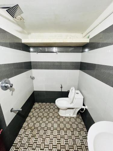 a bathroom with a toilet and a sink at Coffee land in Kaniyāmbetta