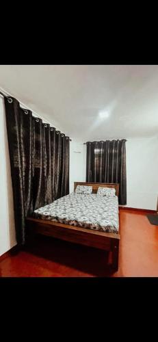 a bed in a room with black curtains at Coffee land in Kaniyāmbetta