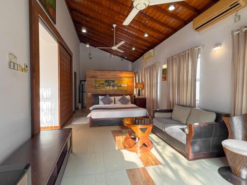 ein Hotelzimmer mit einem Bett und einer Couch in der Unterkunft Atrium Leisure in Boralesgamuwa