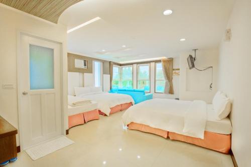 a white room with two beds and a window at Natural Residence B&B in Tai'an