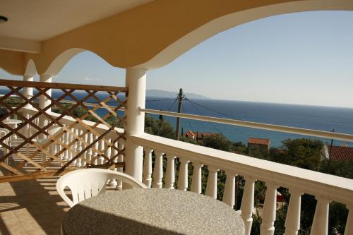 a balcony with a table and a view of the ocean at Marinos Studios at Lourdata village in Lourdhata