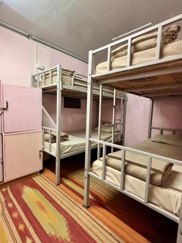 two bunk beds in a room with wooden floors at Shillong Backpackers Hostel in Shillong