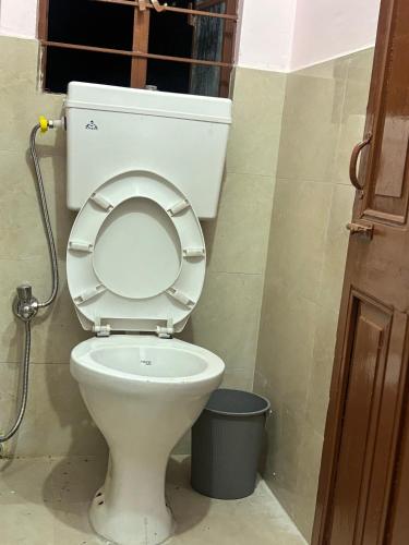 a toilet with the seat up in a bathroom at Shillong Backpackers Hostel in Shillong