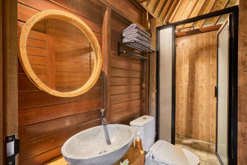 a bathroom with a sink in a wooden wall at Abangan Bungalow in Ubud