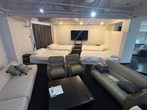 a room with two beds and a couch and a tv at P-STAY広島平和公園withペット 301号室 in Hiroshima
