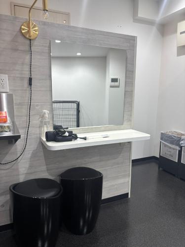 a bathroom with a vanity with a mirror and two black stools at P-STAY広島平和公園withペット 301号室 in Hiroshima