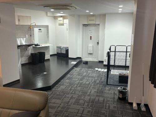 an empty room with a couch in a room with a kitchen at P-STAY広島平和公園withペット 301号室 in Hiroshima