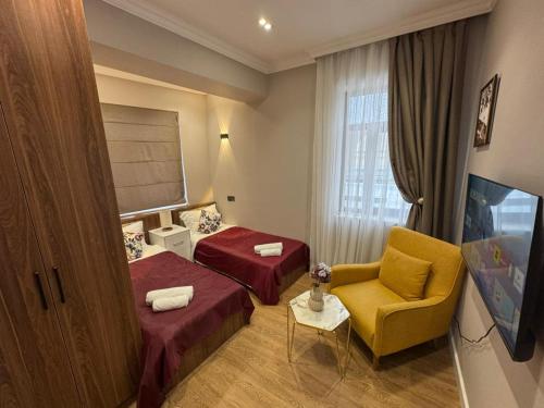 a hotel room with two beds and a chair at Maiden Tower Prestige in Baku