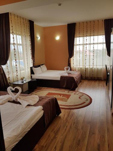 a hotel room with two beds and a rug at Motel Imperial in Roman