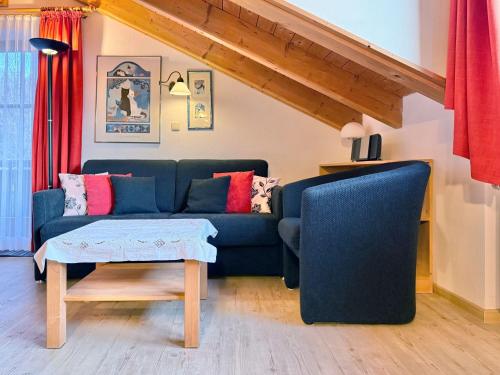 a living room with a blue couch and a table at Sonnenhof Seeg 19 in Seeg