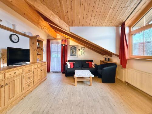 a living room with a couch and a tv at Sonnenhof Seeg 19 in Seeg
