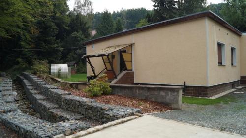 a house with a stone wall next to a building at Ferienwohnung am Park in Greiz
