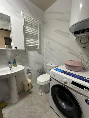 a bathroom with a washing machine and a sink at Solis Residence Batumi in Batumi