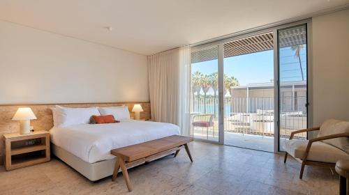 a bedroom with a large bed and a balcony at The Lodge Wadjemup in Rottnest Island