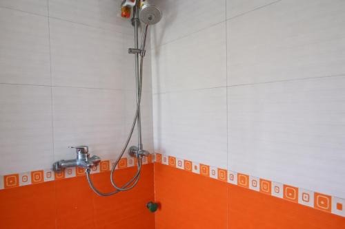 a shower in a bathroom with orange and white tiles at 88 Ehome Noibai Airport in Hanoi