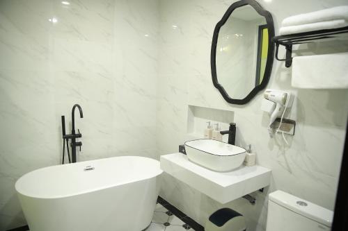 a white bathroom with a sink and a mirror at Gấu Hotel Cầu Giấy in Hanoi