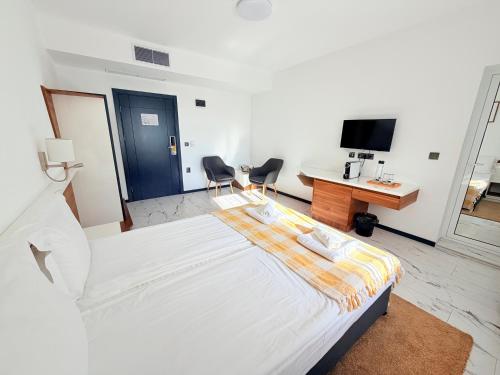 a bedroom with a large white bed and a desk at RUBO Hotel in Shumen