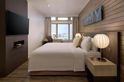 a bedroom with a large bed and a television at PARKROYAL Serviced Suites Singapore in Singapore