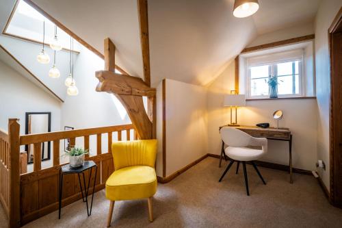 a room with a yellow chair and a desk at The Old Vicarage Irton in Parton