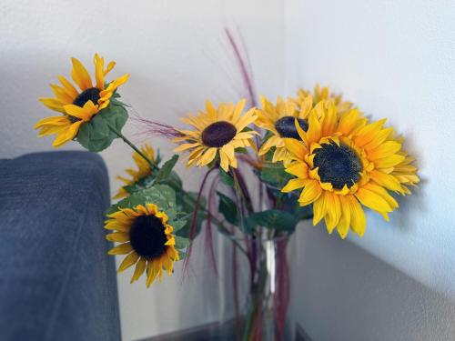 a vase filled with sunflowers sitting on a table at Sonnenhof Seeg 12 in Seeg