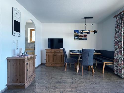 a living room with a dining table and a television at Sonnenhof Seeg 12 in Seeg