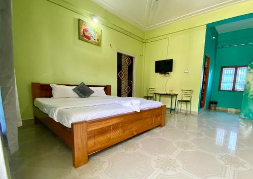 a bedroom with a bed in a room with green walls at Juihal Residency & Kitchen in Kāziranga