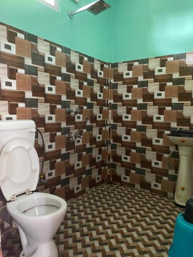 a bathroom with a toilet and a sink at Juihal Residency & Kitchen in Kāziranga